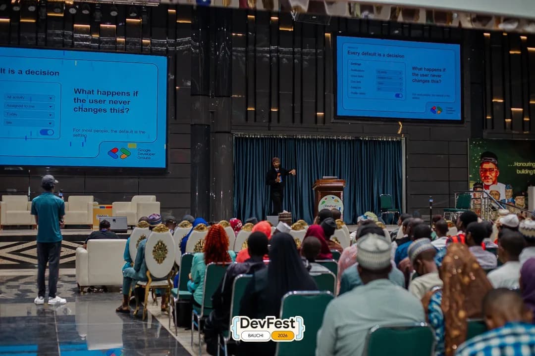 The DevFest Bauchi audience during the talk, facing slides that ask “What happens if the user never changes this?”